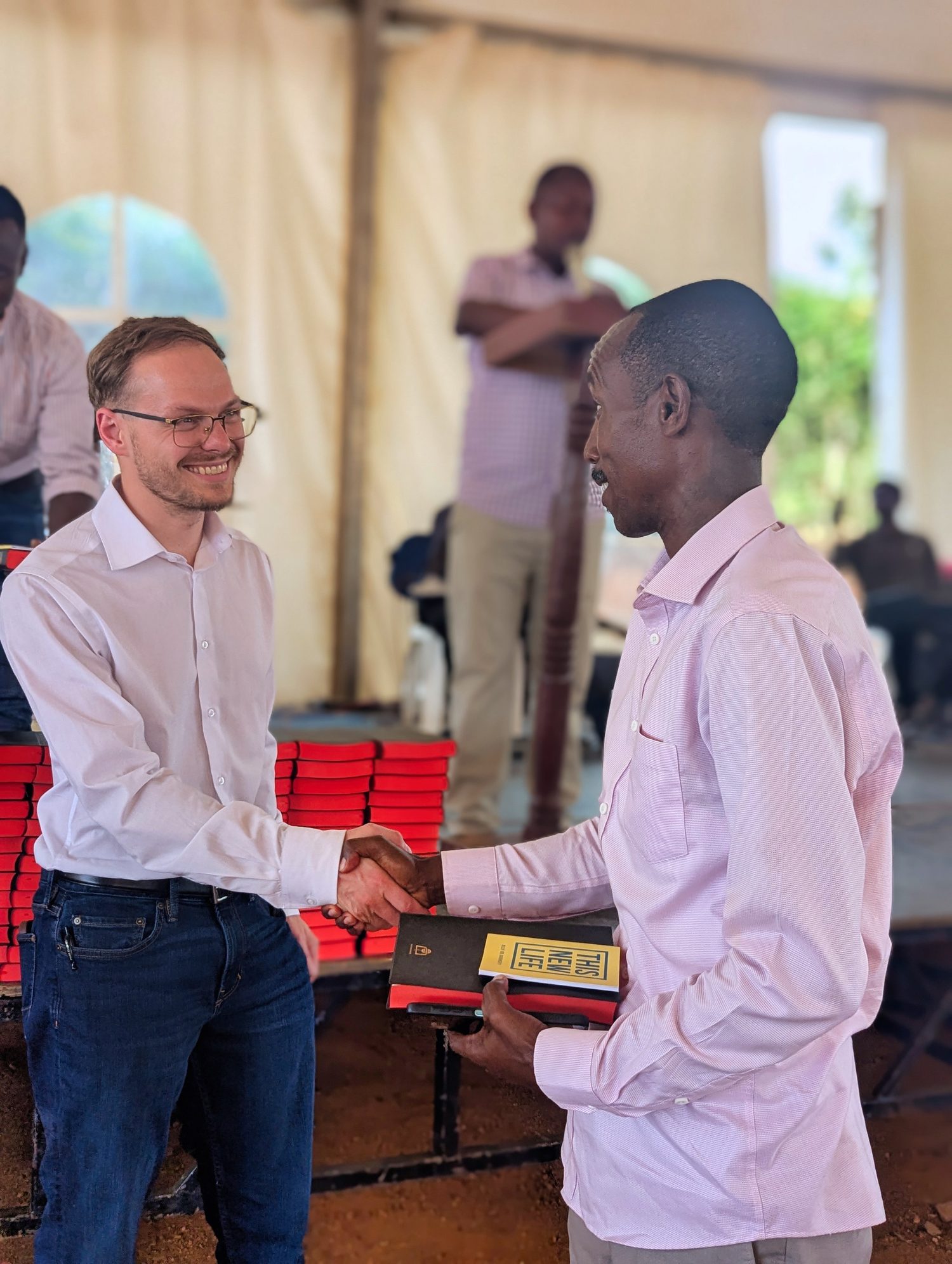 One believer greeting another at the front of the tent.